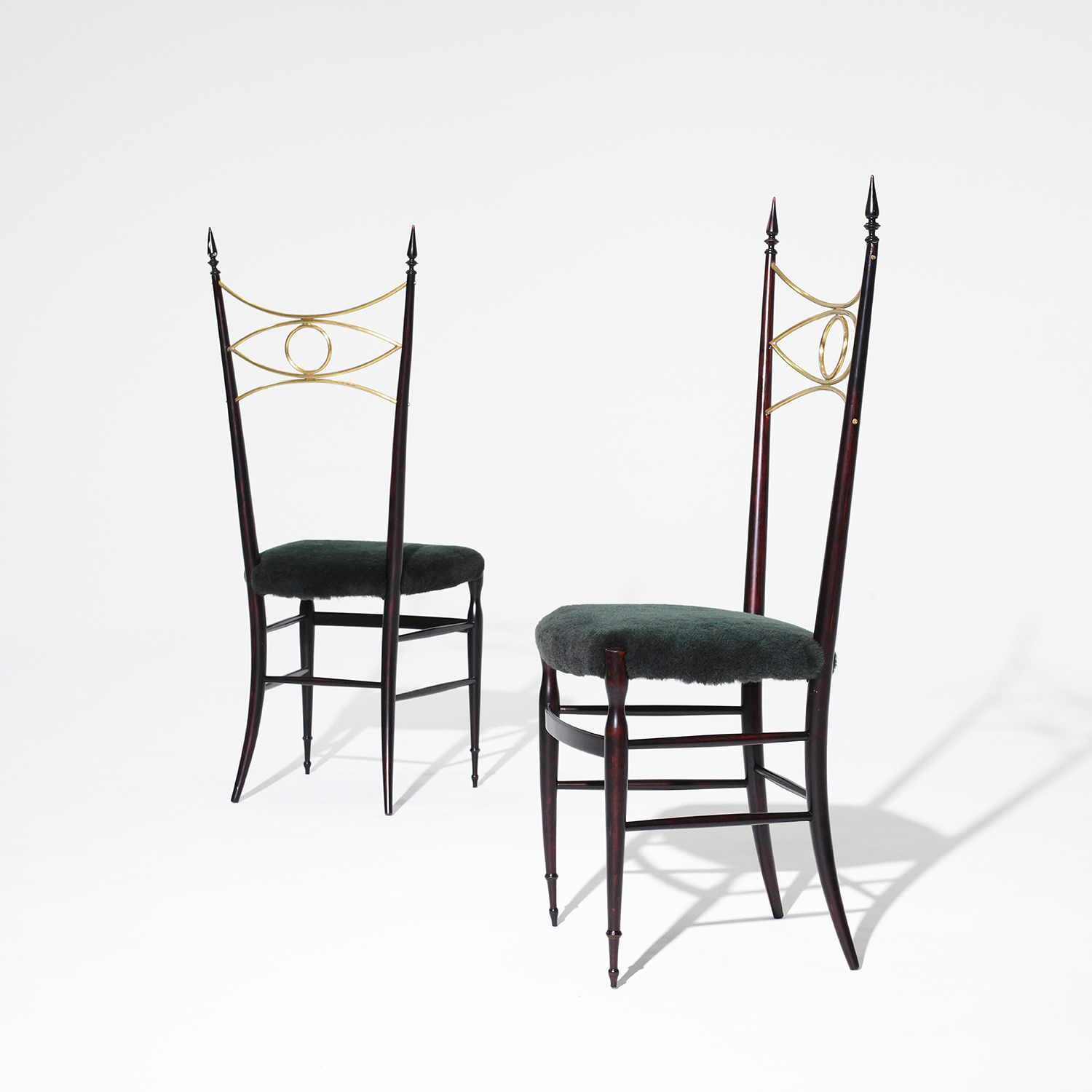 A pair of vintage Mid-Century modern Italian sculptural chairs particularized with an eye-shaped brass bracing. Circa 1940 - 1960, Milan, Italy.